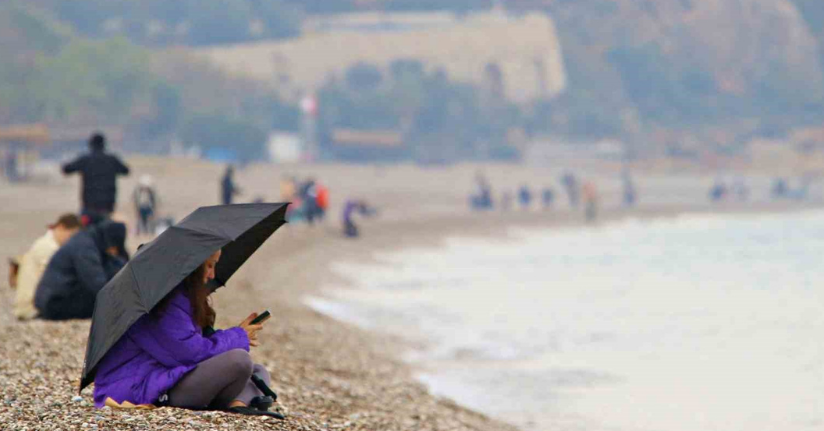 Antalya’da yağmura rağmen şemsiye altında deniz keyfi