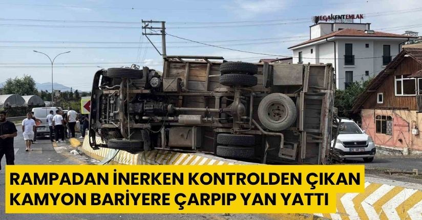 Rampadan inerken kontrolden çıkan kamyon bariyere çarpıp yan yattı